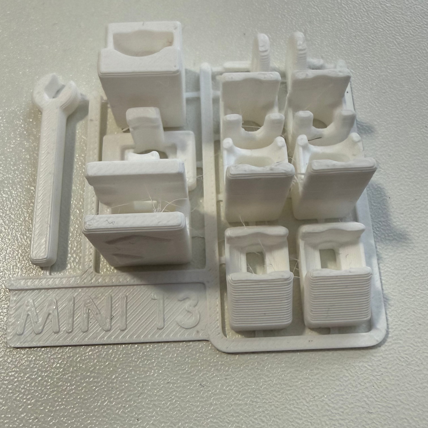 White plastic component with multiple parts on a white background